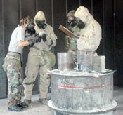 Elizabeth Roach, left, training support instructor, verifies CBRN students' predictions of the chemical agent used inside the gas chamber Friday.